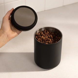 Coffee beans stored in an airtight jar on kitchen counter